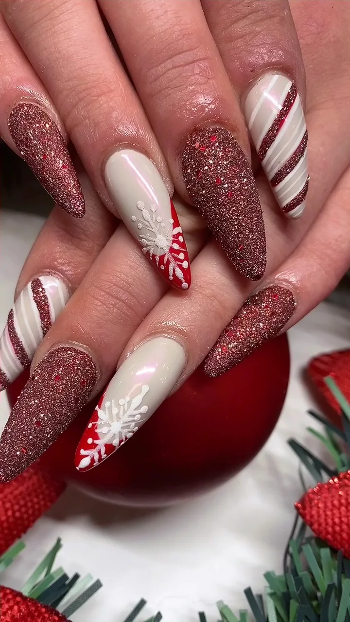 Red glitter candy cane snowflake almond nails on a red bauble
