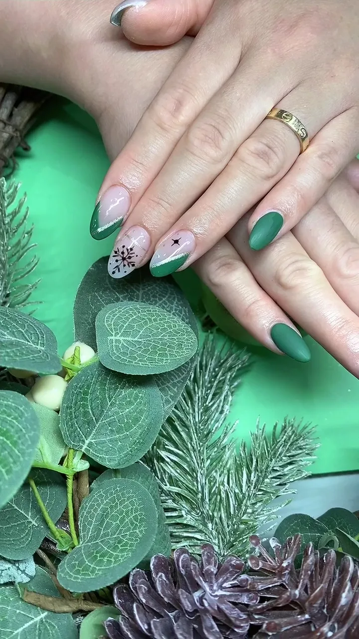 Matte green almond nails with snowflake art on eucalyptus foliage